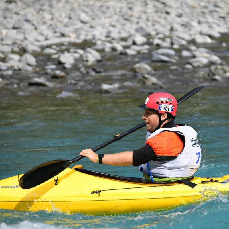 Action shot of David paddling a kayak in whitewater