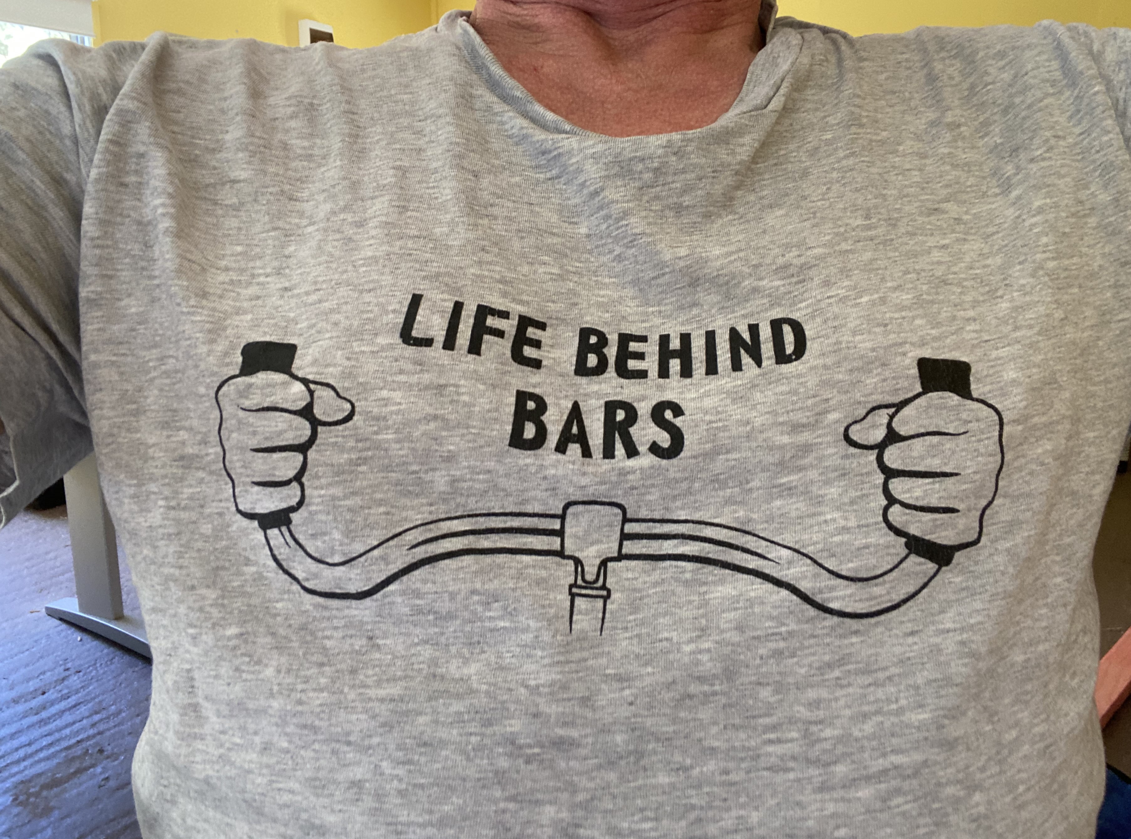 Axel's tshirt, showing a drawing of bicycle handlebars with the caption 'life behind bars'
