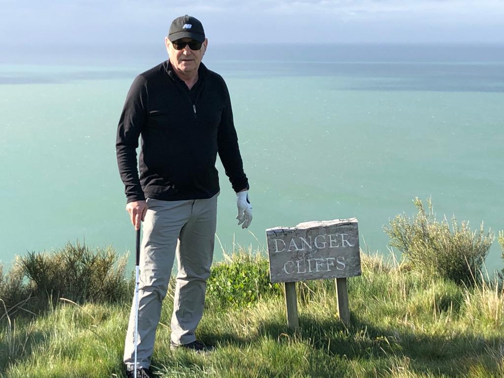 John posing near a cliff on a golf course in Napier
