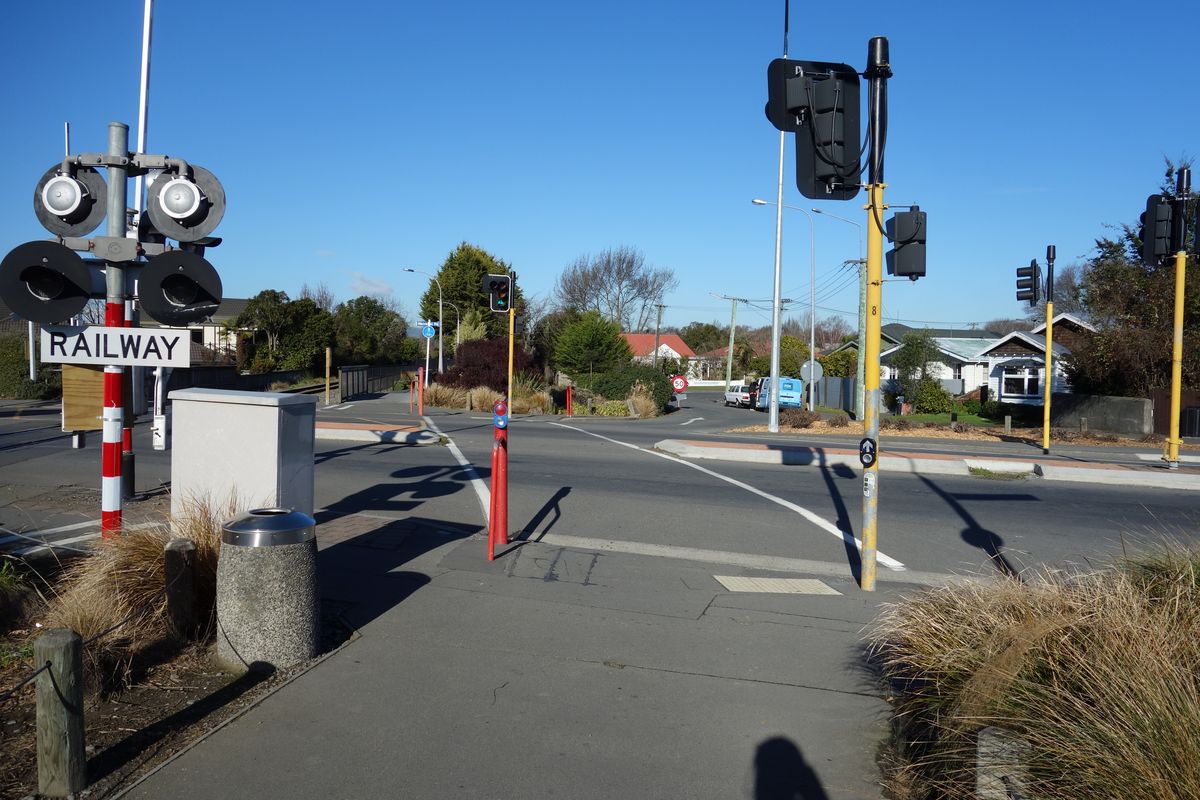 View of signalised pedestrian and cycle crossing parallel to railway line