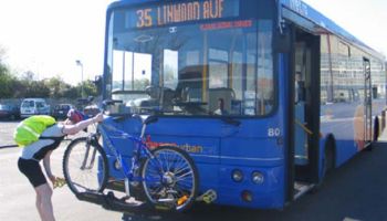cyclist loading a bike in front of bus